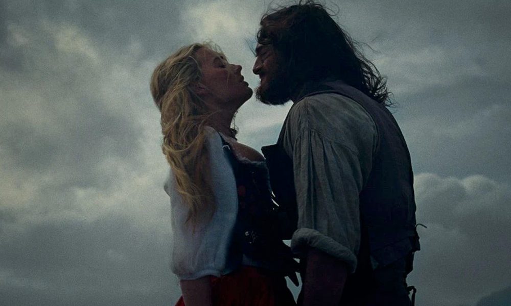 Passionate couple in intense embrace under dramatic sky